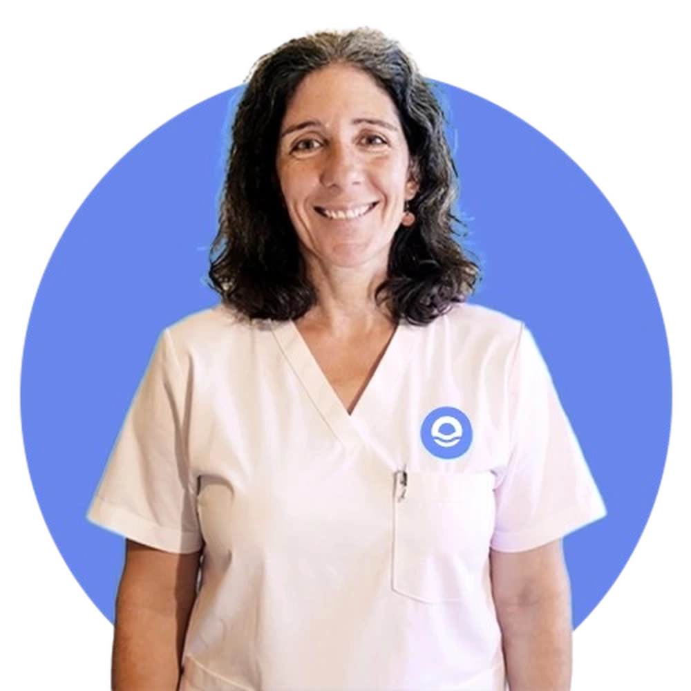 imagen en un fondo de azul violáceo de Celine, nuestra profesora de yoga experta en adicciones, tiene el pelo castaño y a la altura de los hombros, de mediana edad, sonriente y posando con su bata y con el logo de la empresa